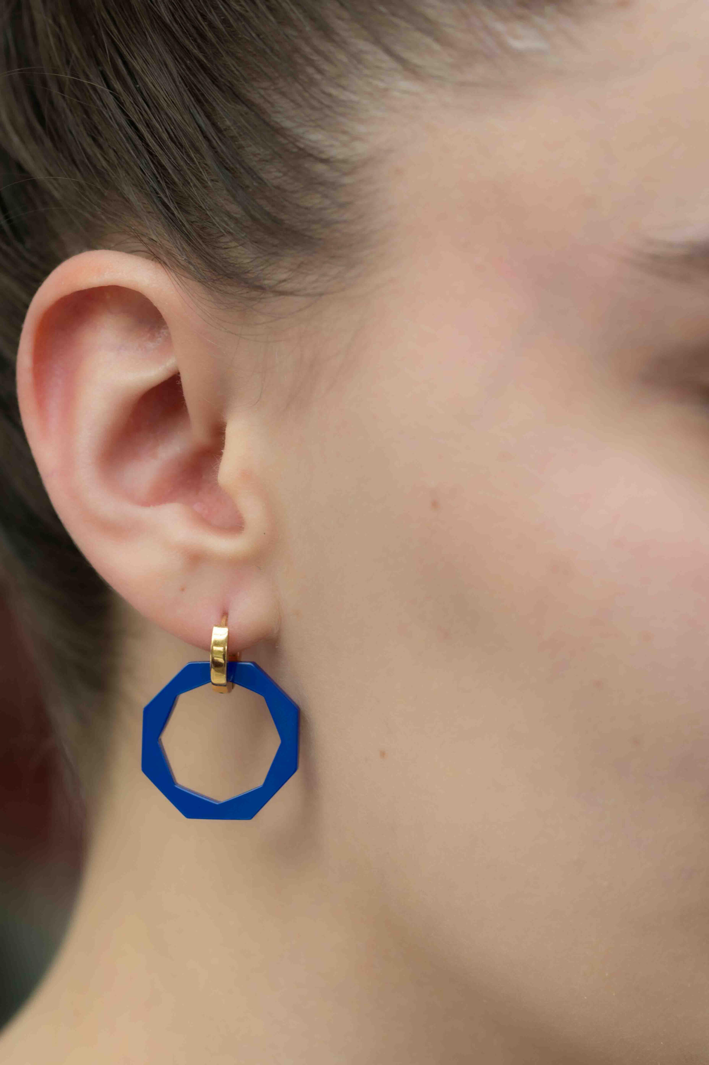 Pendentif Octo-Twist bleu en céramique porté sur chaîne fine dorée